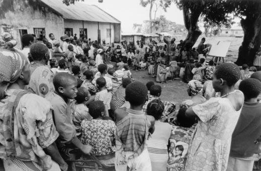 412 Camp residents gather for a lesson in malaria prevention, Harugali camp, Bundibugyo, Uganda, August 2001.