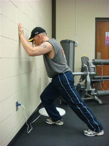 Calf Stretch The starting position is with your feet apart in a walking position and leaning forward with your hands against the wall.