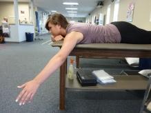 Prone Scaption Lie face down on the edge of a bed/mat with the target arm hanging off the side. Gently raise the arm upwards and outwards 45 degrees from the table as shown.