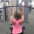 exercise bench with your legs spread. Reach down between your legs and pick up a dumbbell with one hand.