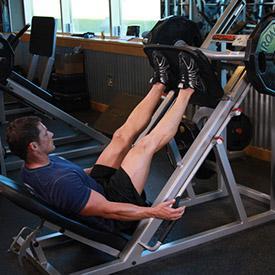 LEG PRESS 1. Using a leg press machine, sit down on the machine and place your legs on the platform directly in front of you at a medium (shoulder width) foot stance.