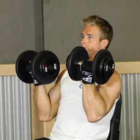 ARNOLD DUMBBELL PRESS 1. Sit on an exercise bench with back support and hold two dumbbells in front of you at about upper chest level with your palms facing your body and your elbows bent.