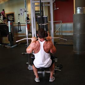 CLOSE GRIP LAT PULLDOWNS 1. Sit down on a pull-down machine with a wide bar attached to the top pulley. Make sure that you adjust the knee pad of the machine to fit your height.