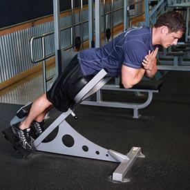 HYPEREXTENSIONS 1. Lie face down on a hyperextension bench, tucking your ankles securely under the footpads. 2.