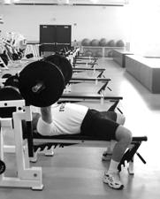 Drop under the dumbbells by re-bending the knees and hips, jumping feet out to the side and locking out elbows.