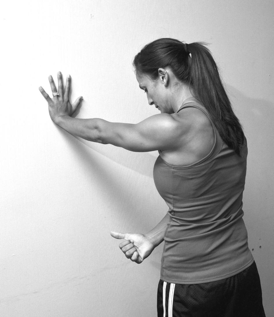 Keep shoulders level as you lift the other hand 1 inch off the wall.