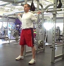 Squat to Press Coaching Tips: Grasp dumbbells, one in each hand with palms facing in.