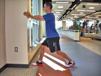Bend both knees, trying to touch the front knee on the wall with the heel pressed to the floor.
