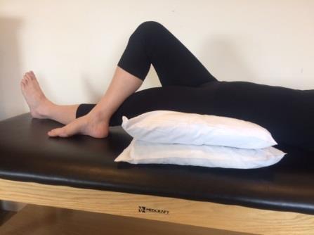 HIP FLEXOR / IT BAND STRETCH Lie on back with two pillows under hips. Reach involved leg down and across midline.
