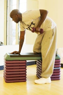 Grab the dumbbell in one hand and bend forward keeping your back level with the ground.