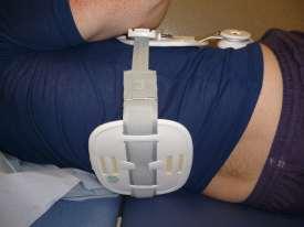 With the brace in place either log roll to one side and place the back pad underneath the spine, or bridge your