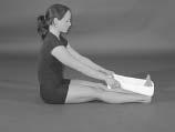 S is in a long sitting position, knees straight, back in ideal posture, hands grasping the ends of a towel or belt, foot and toes pulled up toward head (dorsi flexed) as far