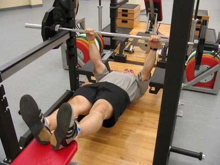 Lower the bar to the top of the chest, then drive the bar up