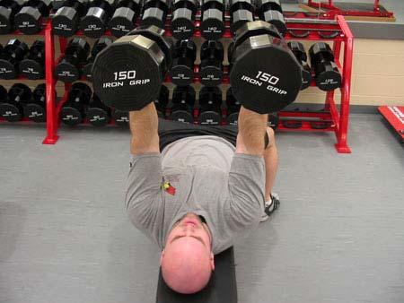 Sit down on the bench with dumbbells resting on your lower