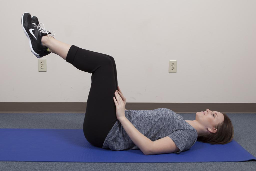 This photo shows an advanced exercise. Abdominal Press: This exercise improves core stability and spinal alignment. Lie on the floor. Bend your knees. Inhale slowly.