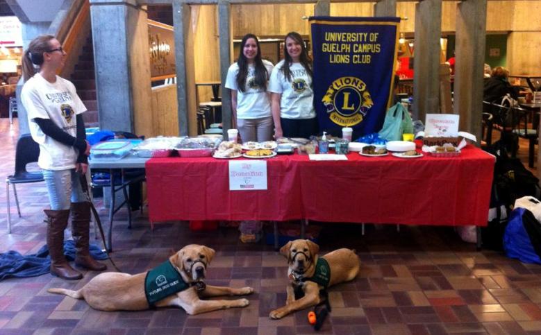 Page 2 * District A-15 Bulletin Campus fundraiser From left to right is Lion Bianca, Lion Megan and Lion Ashley. In front are Future Dog Guides Chip and Petrie.