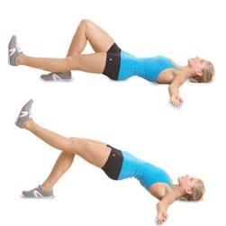Hold a dumbbell in each hand with elbows slightly bent. Bend forward at the waist and keep a slight bend in the knees.