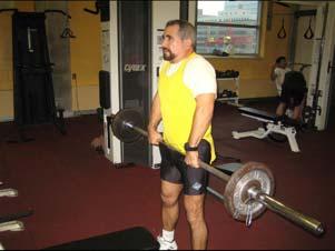 Raise bar bell by shrugging shoulders forward and upward, as high as possible.