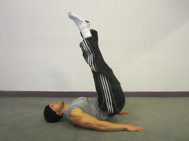 Core Reach Lay flat on the floor, legs straight up to the ceiling, heel of the palms pressed down to the floor, keep both arms as close as possible to the body.